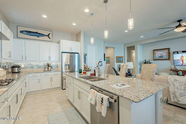 kitchen featuring white cabinetry, appliances with stainless steel finishes, sink, and a center island with sink