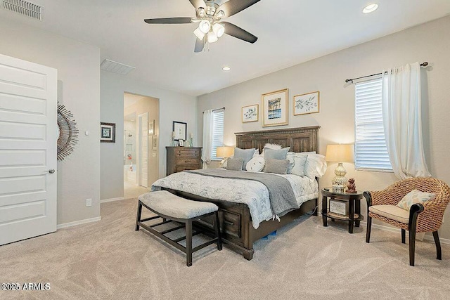 bedroom featuring connected bathroom, light colored carpet, and ceiling fan