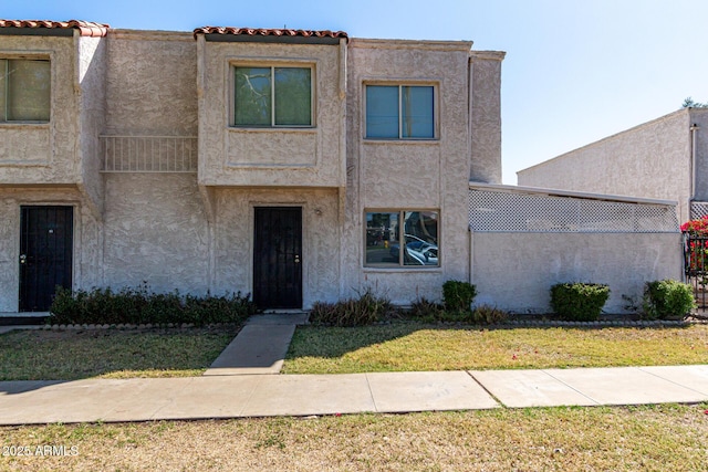 townhome / multi-family property featuring stucco siding and a front lawn
