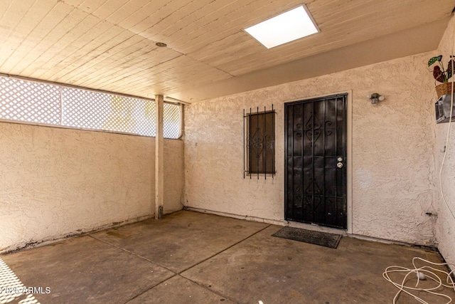 entrance to property with stucco siding and a patio