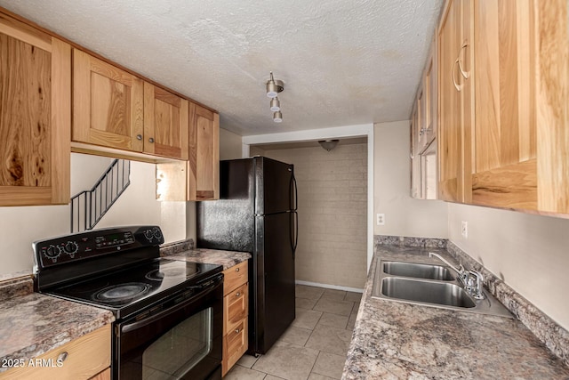 kitchen featuring a sink, a textured ceiling, and black appliances