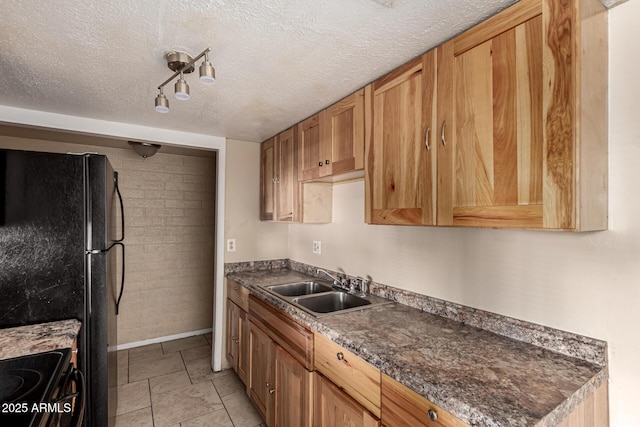 kitchen with baseboards, a textured ceiling, a sink, dark countertops, and black appliances