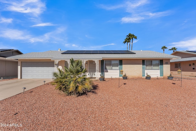 ranch-style house featuring solar panels and a garage