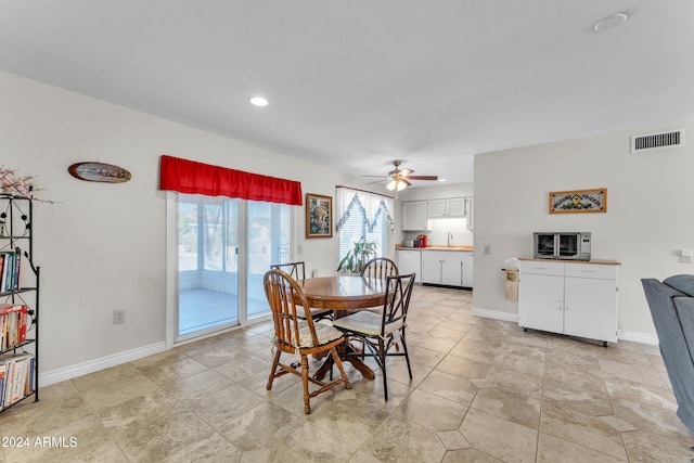 dining area featuring ceiling fan and sink