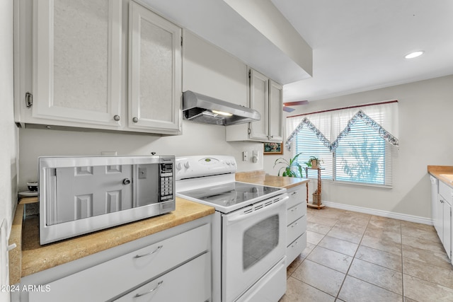 kitchen with white cabinetry, light tile patterned floors, range hood, and white electric range