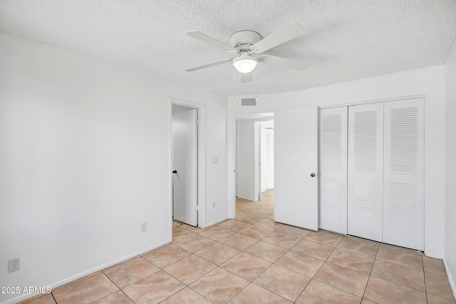 unfurnished bedroom featuring light tile patterned flooring, ceiling fan, and a closet