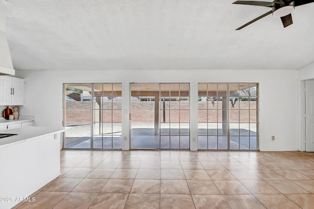 unfurnished living room with lofted ceiling, plenty of natural light, and light tile patterned floors