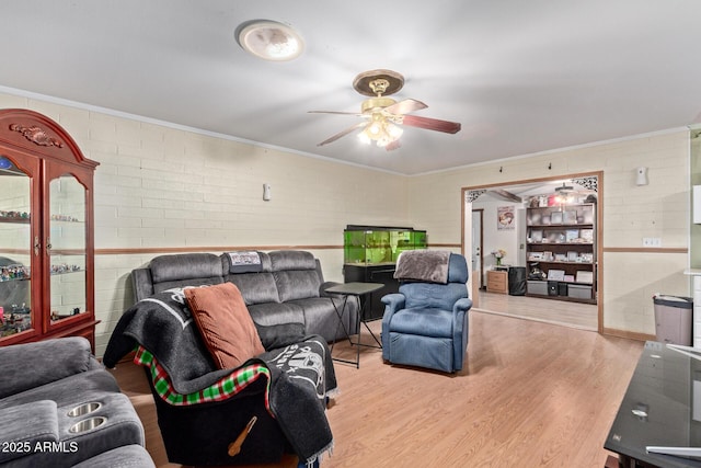 living room with ceiling fan, ornamental molding, brick wall, and light wood-type flooring