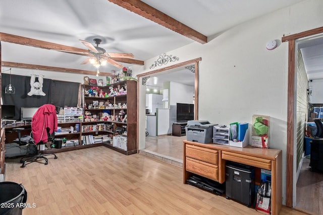 home office with ceiling fan, beamed ceiling, and light wood-type flooring