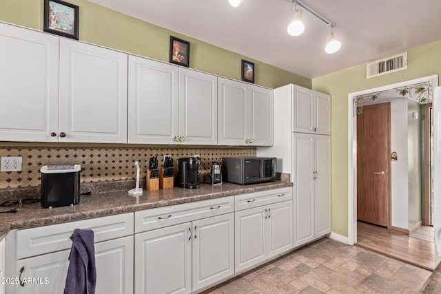 kitchen with white cabinetry and tasteful backsplash