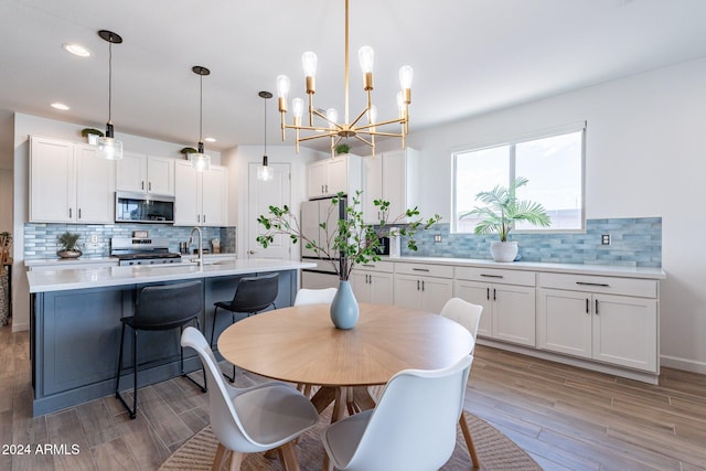 dining space with a notable chandelier and light hardwood / wood-style floors