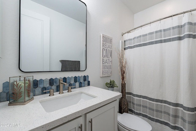 bathroom featuring a shower with shower curtain, vanity, and toilet