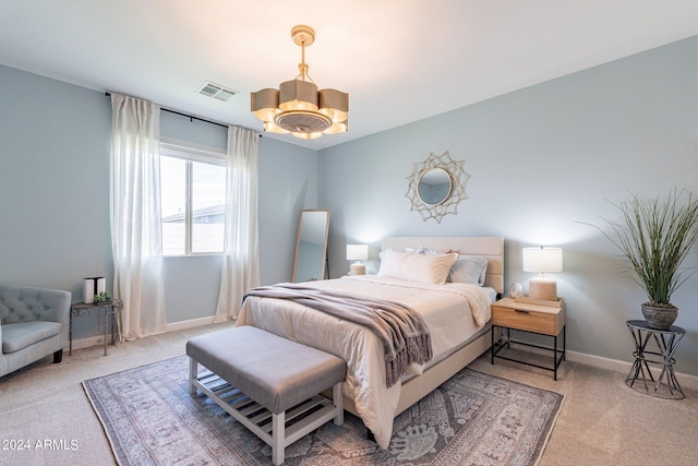 bedroom with an inviting chandelier and light carpet