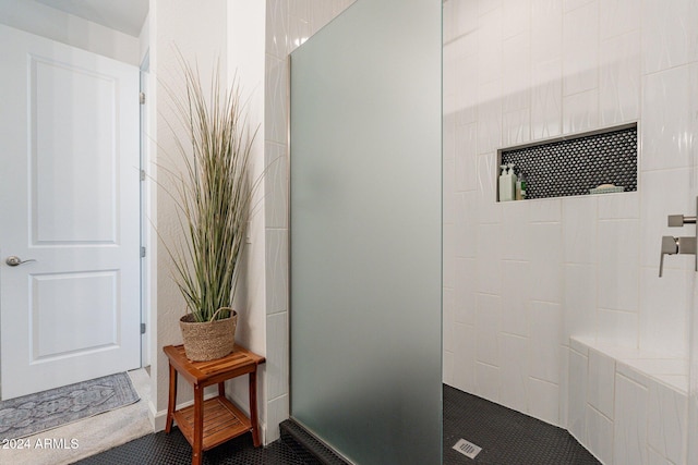 bathroom featuring tiled shower and tile patterned floors