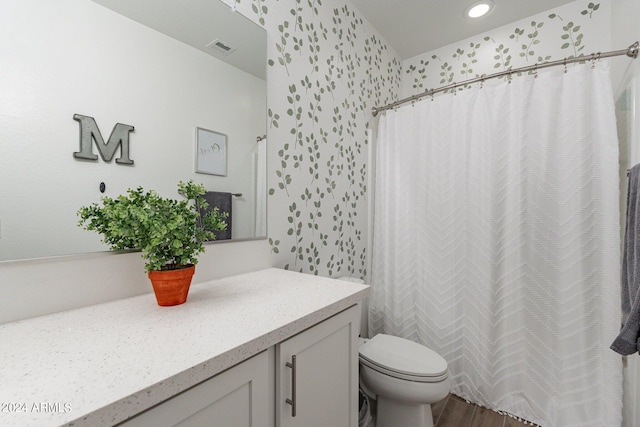 bathroom with hardwood / wood-style floors, toilet, vanity, and curtained shower