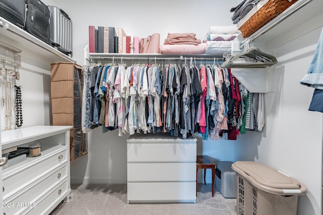 walk in closet featuring light colored carpet