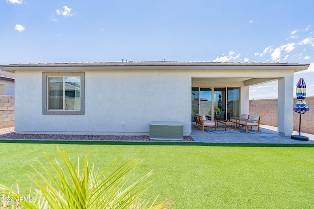 rear view of property featuring cooling unit, a patio area, and a yard