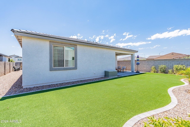 back of house featuring a patio and a yard