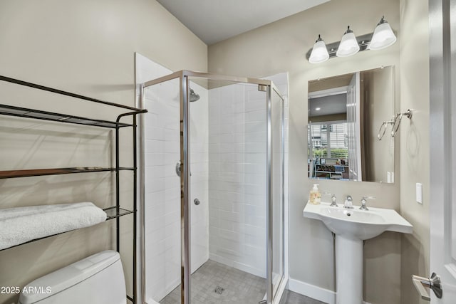 bathroom featuring a shower stall, toilet, and a sink