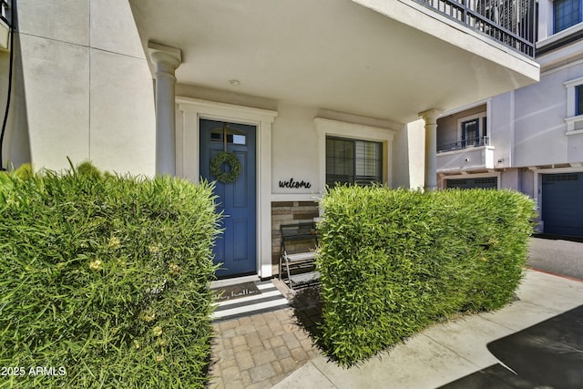 doorway to property with stone siding and stucco siding