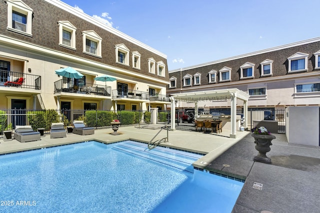 pool featuring area for grilling, a patio, and fence