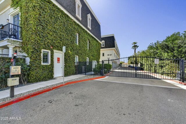 exterior space featuring a gated entry, sidewalks, curbs, and a gate