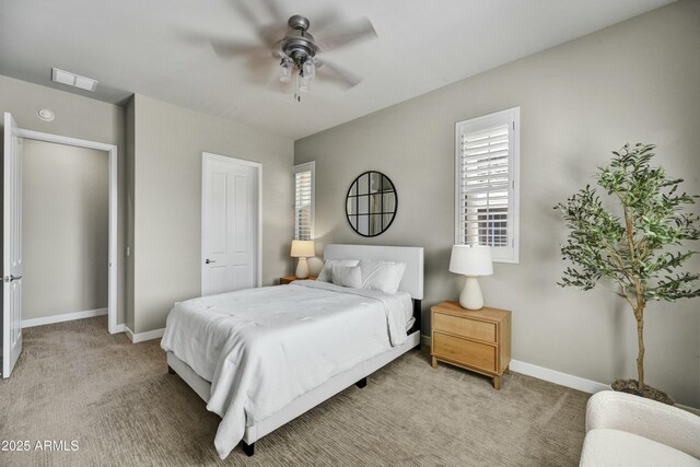 bedroom with visible vents, light colored carpet, baseboards, and ceiling fan