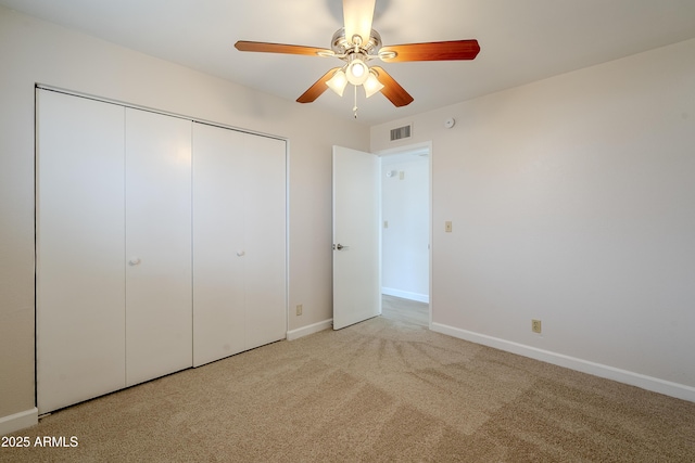 unfurnished bedroom with ceiling fan, light colored carpet, and a closet