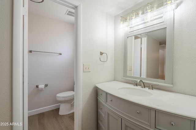 bathroom featuring vanity, hardwood / wood-style flooring, and toilet