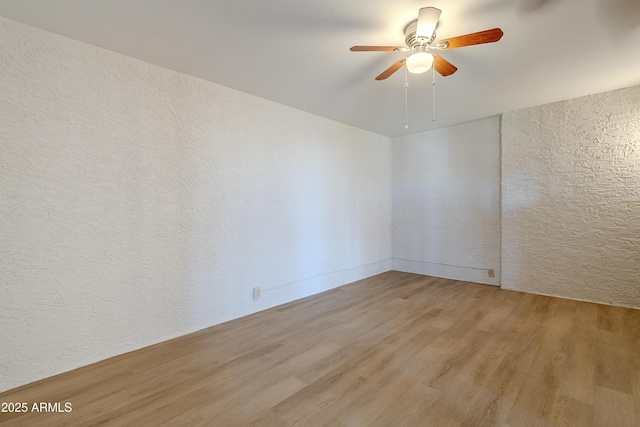 spare room featuring ceiling fan and light hardwood / wood-style flooring