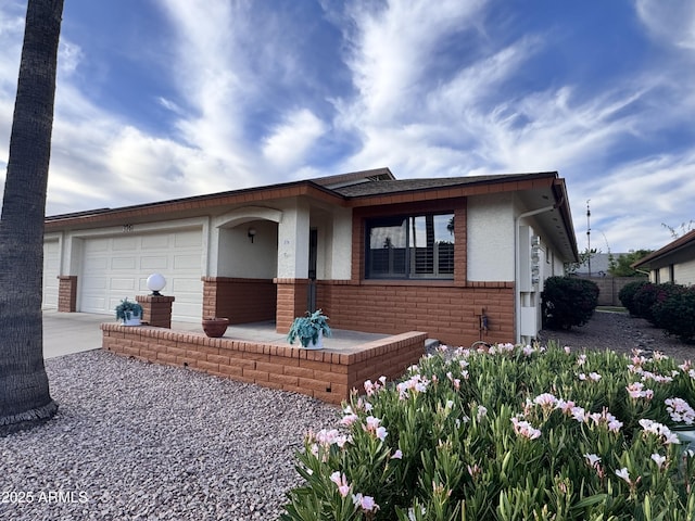8161 E Keats Ave Unit 376, Mesa, AZ 85209 - view of front of property with a garage, concrete driveway, brick siding, and stucco siding