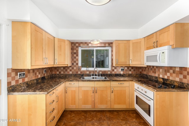 kitchen with tasteful backsplash, sink, white appliances, dark stone countertops, and light brown cabinetry