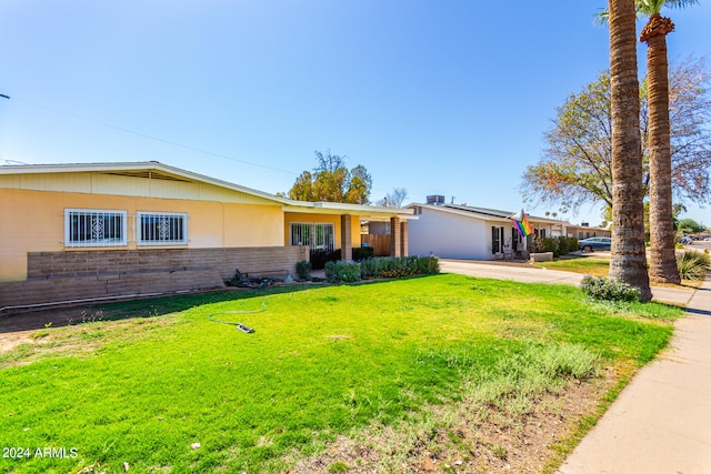 ranch-style home with a front lawn