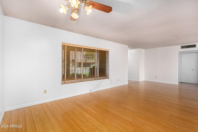 empty room featuring a textured ceiling, wood-type flooring, and ceiling fan