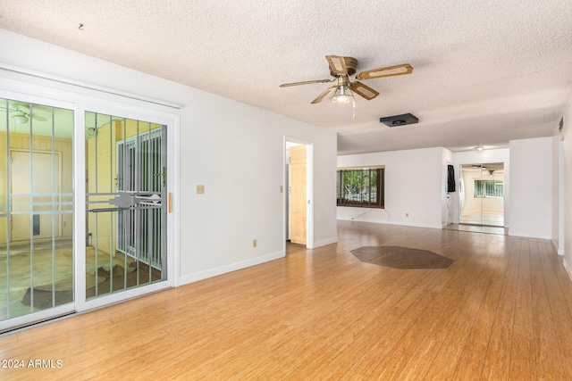 unfurnished living room with wood-type flooring, ceiling fan, and a textured ceiling