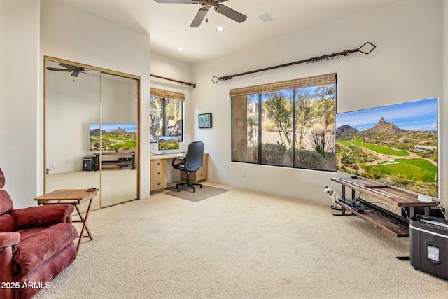 carpeted office space featuring ceiling fan