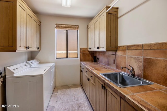 laundry room featuring cabinets, independent washer and dryer, light tile patterned floors, and sink