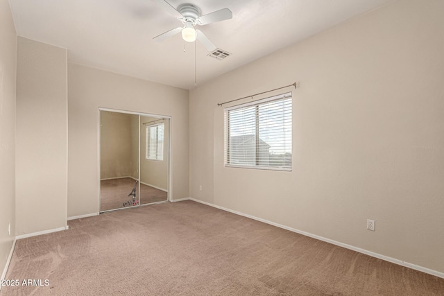 unfurnished bedroom featuring carpet floors, baseboards, visible vents, and multiple windows