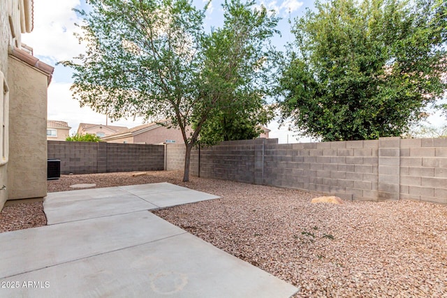 view of yard with a fenced backyard, a patio area, and central AC unit