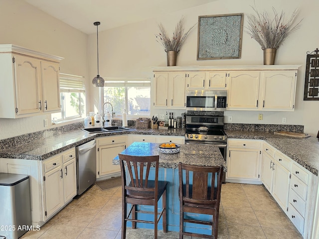 kitchen featuring pendant lighting, sink, light tile patterned floors, and stainless steel appliances