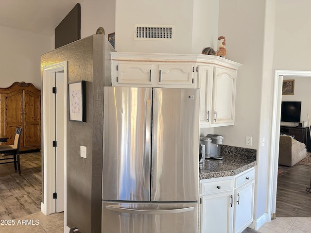 kitchen featuring white cabinetry, light wood-type flooring, and stainless steel refrigerator