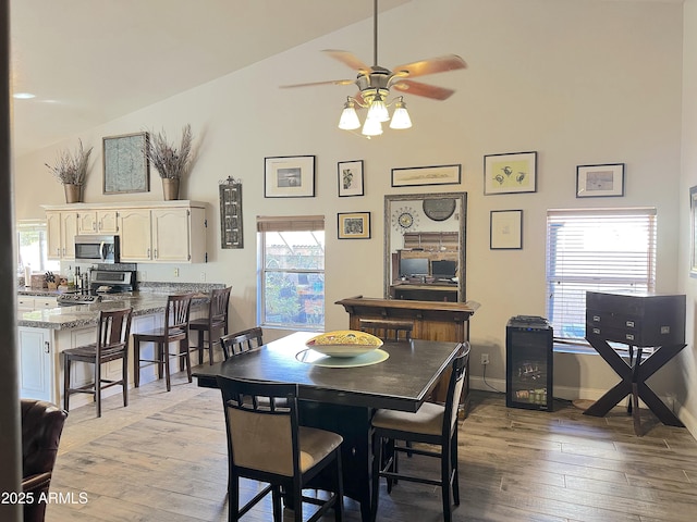 dining space with lofted ceiling, ceiling fan, and light hardwood / wood-style flooring