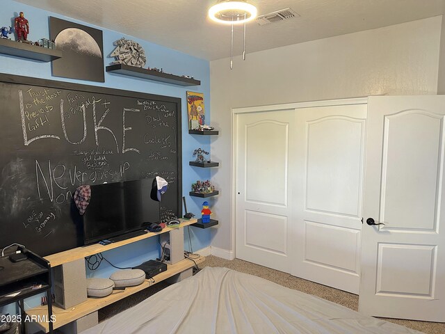 bedroom featuring light colored carpet and a closet