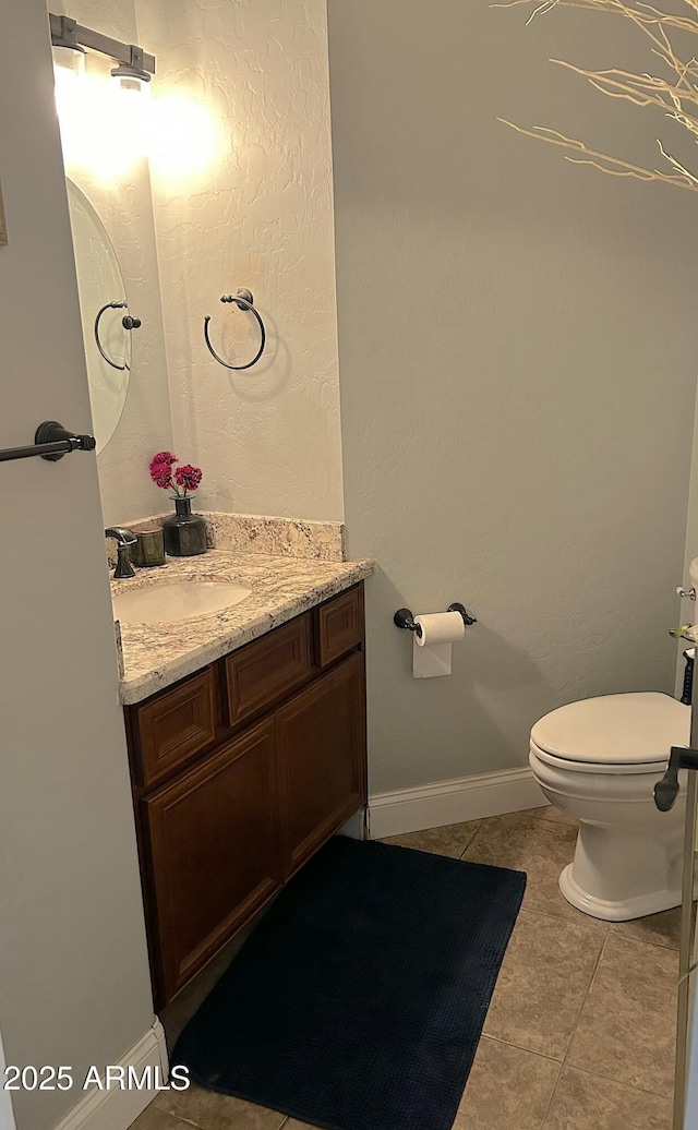 bathroom with vanity, tile patterned floors, and toilet