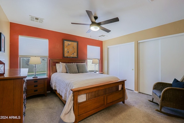 bedroom with multiple windows, light colored carpet, and ceiling fan