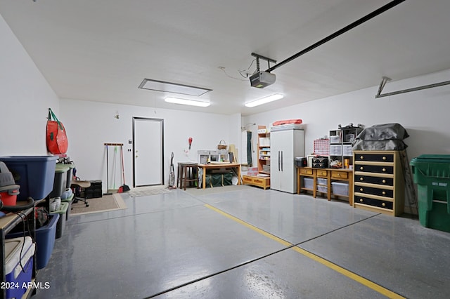 garage featuring a garage door opener and white refrigerator