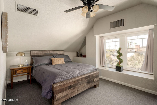 carpeted bedroom featuring a textured ceiling, vaulted ceiling, and ceiling fan