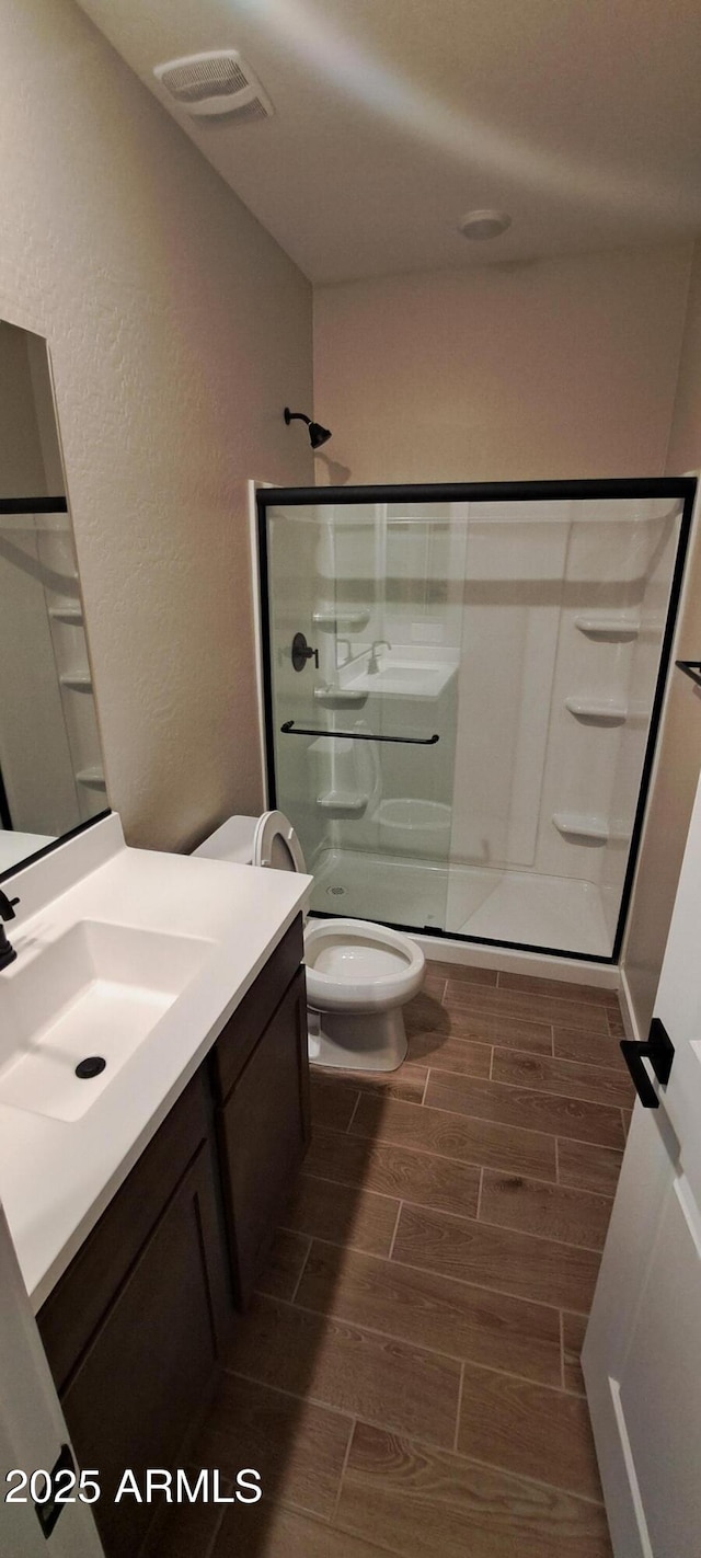 15587 S 180th Ln, Goodyear, AZ 85338 - bathroom with wood tiled floors, toilet, a stall shower, vanity, and a textured wall