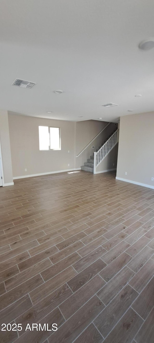 15587 S 180th Ln, Goodyear, AZ 85338 - unfurnished living room featuring dark wood-style floors, stairway, and baseboards