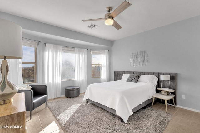 bedroom featuring ceiling fan, light tile patterned flooring, visible vents, and baseboards